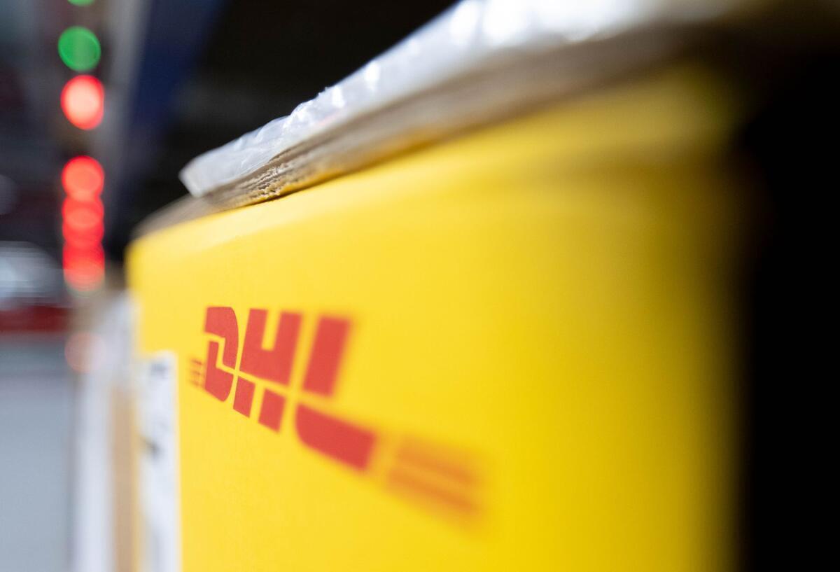DHL erhöht erneut die Preise – das kommt jetzt auf Kunden zu Das Logo von DHL an einer Packstation