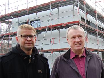 Diakon Christoph Richter (links) und Pfarrer Karl Jasbinschek freuen sich, dass die Arbeiten am neuen Pfarrzentrum zügig voranschreiten. Beim Haupteingang wird noch der Schriftzug „St. Willehad Pfarrbüro“ angebracht.