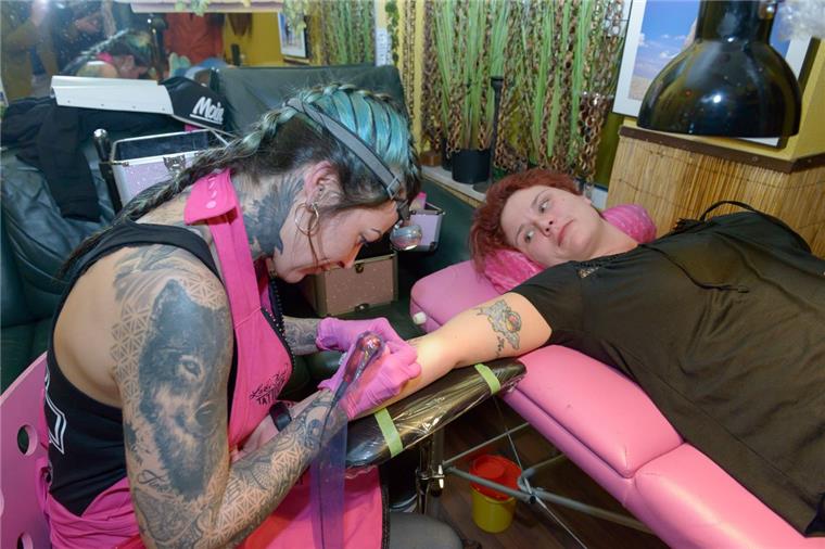 Die 6. Nacht der Hautkunst in der Bürger. Im Lady Tees: Damaris Gerken läßt sich von Judith Erbap (Lady June Tattoo) das rumänische Wort für "Familie" tätowieren. 