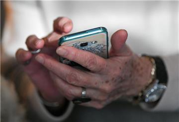 Eine Seniorin hält ihr Smartphone in den Händen