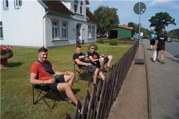 Die Anwohner Michael, Janes und Kevin (von links) beobachten das Treiben beim De...