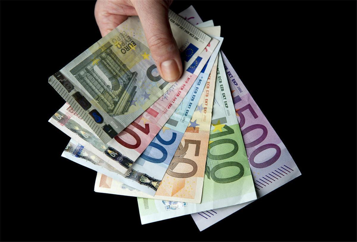 Eine Hand hält zahlreiche Euro-Banknoten.