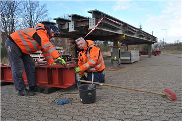 Die Arbeiter Walter Kolrep (links) und Gunnar Falkenthal montieren nördlich des Hauptbahnhofs die neue Brücke für die Parkstraße.  Foto: Beschnitt