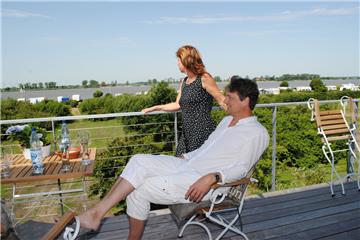 Die Bauherren Kirsten Braband und Martin Winter aus Bremen genießen von der Terrasse ihres Stelzenhauses in Rechtenfleth den Blick über die Landschaft. 