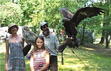 Die beiden Falkner Regine Liebtrau und Uwe Tietz mit der Besucherin Kiana sowie Uhu Fritz und Steinadler Alic.