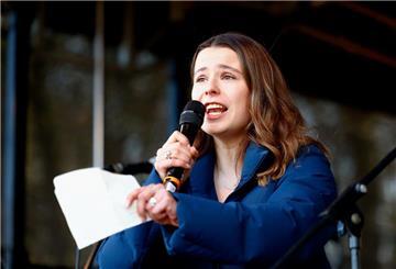 Luisa Neubauer, Klimaaktivistin, steht auf einer Bühne und spricht in ein Mikrofon. 