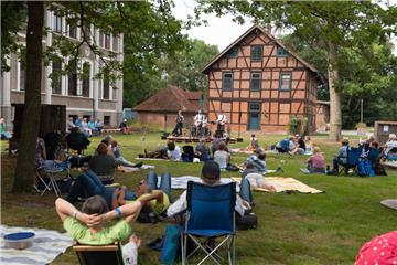 Die Besucher genießen die herrlich entspannte Atmosphäre auf dem Klostergut Burgsittensen und lauschen der Live-Musik.  