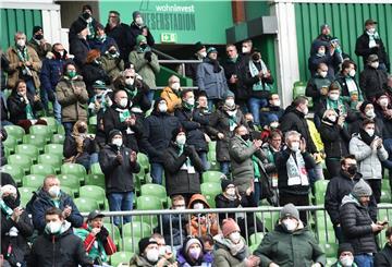 Werder Bremen Fans sitzen und stehen im Weserstadion und applaudieren.