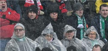 Die Bremer Fans sitzen in Freiburg im Regen.