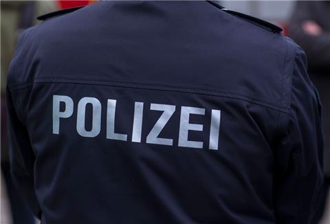  "Polizei" steht auf der Uniform eines Polizisten. 