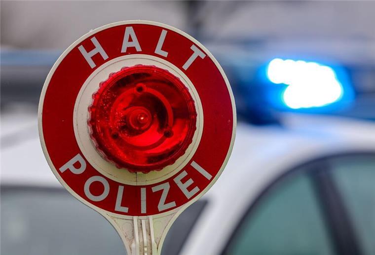 ein Polizist hält eine Polizeikelle für eine Kontrolle