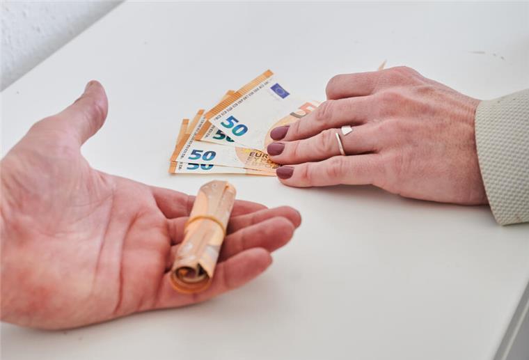 Bremerhaven: Schlechtere Chancen für Frauen und weniger Gehalt Eine Männerhand (links) hält ein Bündel 50-Euro-Scheine, während eine Frauenhand nur wenige 50-Euro-Scheine hält.