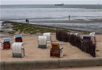 Strandkörbe stehen am Strand von Cuxhaven-Döse unter grauem Himmel. 