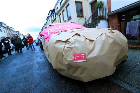 Die Bürgerinitiative "Platz da!" und der Allgemeine Deutsche Fahrrad-Club (ADFC) Bremen haben in Bremen-Findorff ein falsch geparktes Auto mit Geschenkpapier eingepackt.