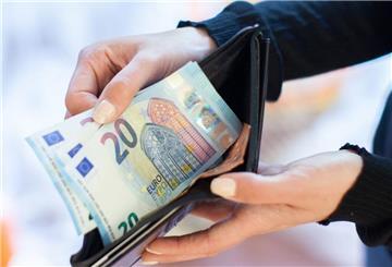 Eine Person hält mehrere 20-Euro-Scheine in die Kamera. 