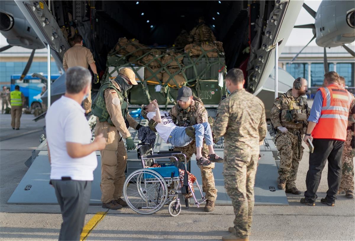 Mehr als 4650 Menschen von Bundeswehr aus Kabul evakuiert Während der militärischen Evakuierungsoperation von Schutzbedürftigen aus der afghanischen Hauptstadt Kabul tragen deutsche Bundeswehrsoldaten einen Afghanen aus dem Laderaum eines Airbus A400M und setzen ihn in einen Rollstuhl.