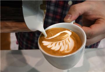 27.02.2018, Bremen: Ein Barista stellt bei der "Latte Art" Meisterschaft seine Milchschaumkreation her. Bei "Latte Art" dreht sich alles um die Zubereitung von Milchschaum.