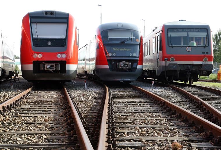 Drei Wagen der Deutschen Bahn stehen auf Schienen. 