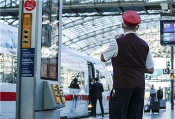 Ein Zugbegleiter gibt ein Abfahrtszeichen für einen ICE auf dem Bahnsteig im Berliner Hauptbahnhof. 
