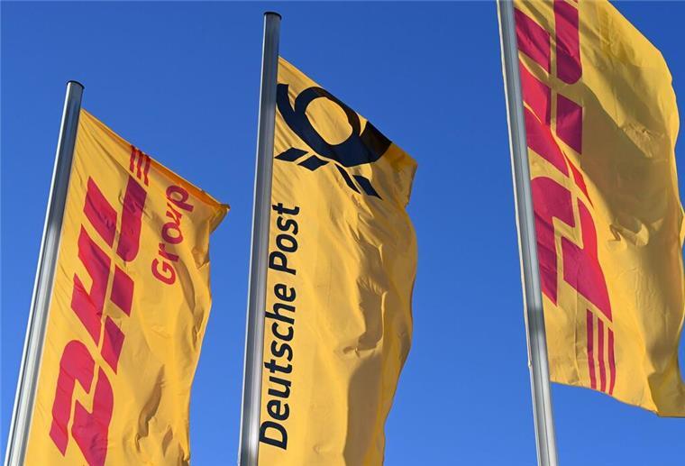 Stellenabbau bei der Deutschen Post: 8000 Arbeitsplätze betroffen Fahnen des Logistikkonzerns DHL und seiner Brieftochter Deutsche Post (M) wehen vor der Konzernzentrale an Masten. (zu dpa: «Deutsche Post streicht 8.000 Stellen»)