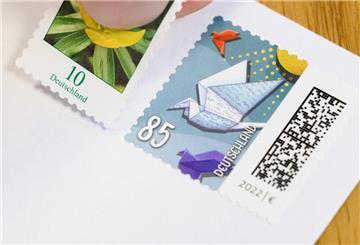 ILLUSTRATION - 13.11.2024, Niedersachsen, Hannover: Eine 10-Cent-Briefmarke wird neben eine 85-Cent-Briefmarke geklebt (gestellte Szene). Der Versand eines Standardbriefs innerhalb Deutschlands soll ab Januar 95 Cent kosten und damit 10 Cent mehr als bislang. Das hat die Deutsche Post am 13.11.2024 vorgeschlagen. Foto: Julian Stratenschulte/dpa +++ dpa-Bildfunk ++