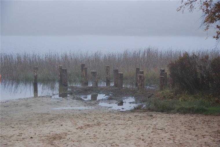 Die DLRG-Wachstation am Silbersee in Wehdel (Schiffdorf) ist weg. An ihrer Stelle ragen Eichenpfähle aus dem flachen Wasser am Strand.