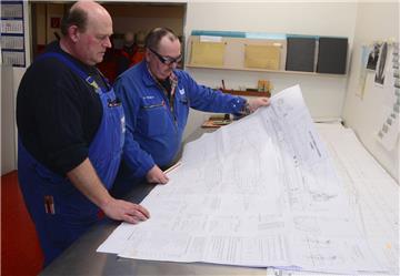 Die Dockmeister  Holger Brüning  (links) und Reiner Riggers studieren den Plan des nächsten Schiffes, das ins Dock soll.  Foto Scheer