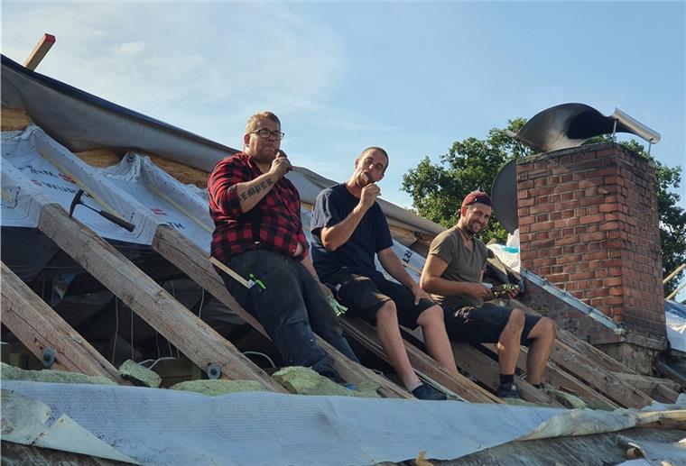 Die drei Dachdecker Tim Baumgart, Simon Brunje und Jannis Vollers (v.l.) trotzen der Hitze auf dem Dach mit einem Eis.