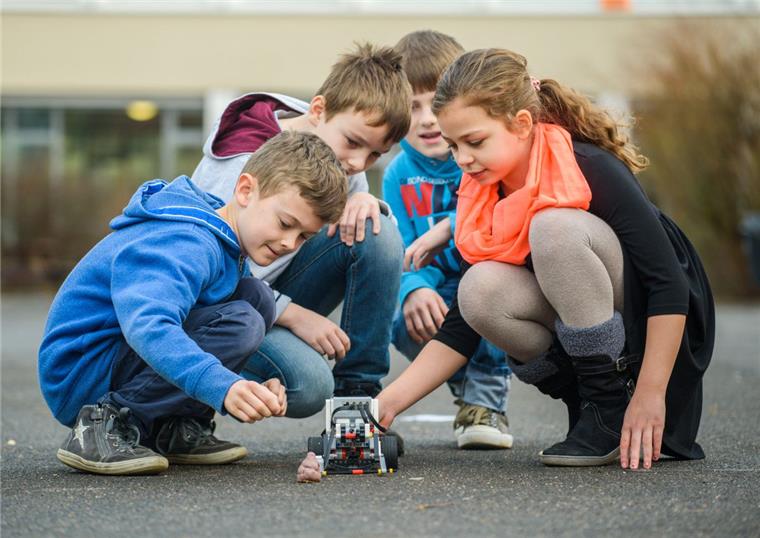 Die Drittklässler Noah Stürmer (von links), Benjamin Brändlein, Jeremias Tuschinski und Moesha Miller führen den selbst entwickelten Roboter "Schwein-Robo" vor. Mit dem Roboter, der Hundehaufen wegräumt, haben die Drittklässler der Schweinfurter Auenschule den ersten Platz des "Weltretter-Wettbewerbs" gewonnen.