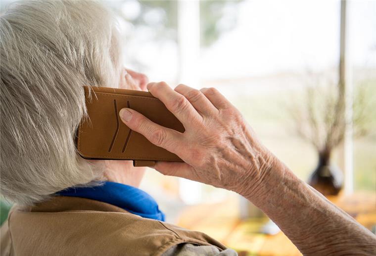  Eine Seniorin telefoniert mit ihrem Smartphone.