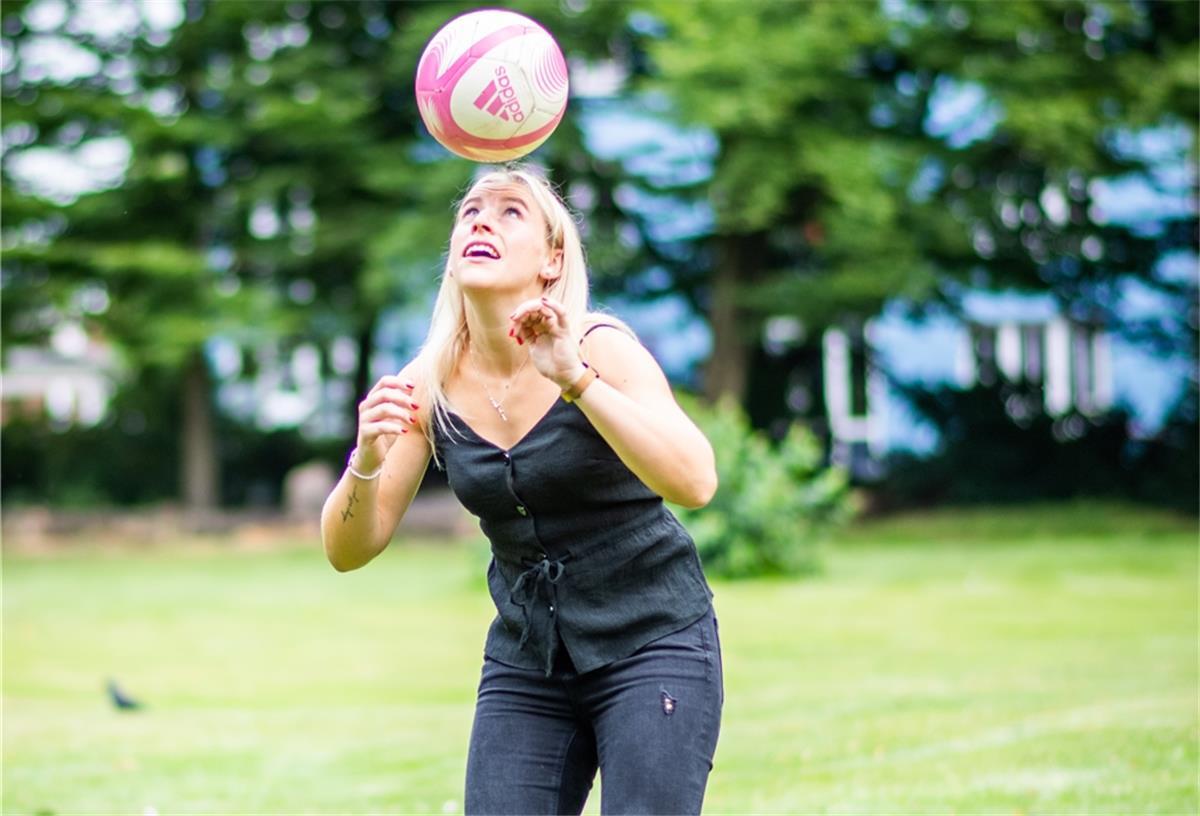 Frau spielt Fußball.