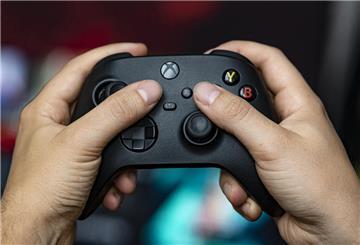 Ein Mann hält einen Kontroller der Spielekonsole Xbox Series X in der Hand