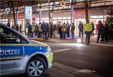 Polizeiauto im Vordergrund, im Hintergrund eine Menschenansammlung.