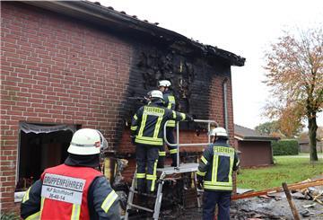 Die Einsatzkräfte der Feuerwehr kontrollieren die Hausfassade.