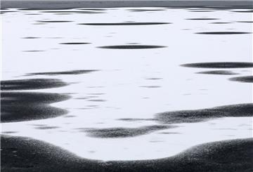 Im Stadthafen an der Müritz liegt Schnee auf einer Eisfläche, auf den anderen Flächen ist er bereits weggetaut. 