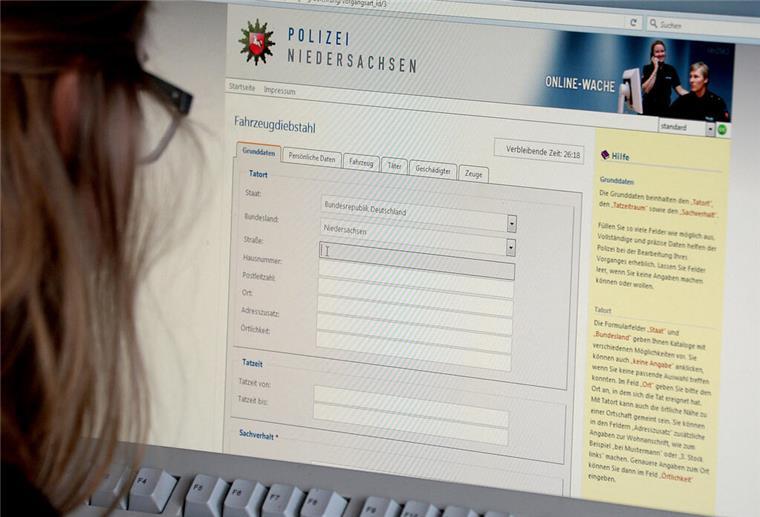 Eine Frau blickt auf einen Bildschirm mit einem Online-Wache-Portal der Polizei Niedersachsen
