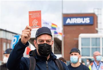 Beschäftigte des Airbus-Werkes in Finkenwerder stehen während einer außerordentlichen Betriebsversammlung vor den Toren des Werksgeländes und zeigen dem Management des Unternehmens dabei symbolisch die rote Karte.