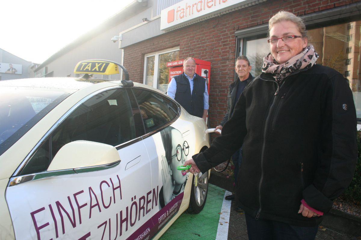 Die Fahrer sind begeistert von ihrem neuen Taxi, das einfach an der Ladesäule „aufgetankt“ wird (von rechts): Renate Otten, Frank Romerke und Carsten Ecke.