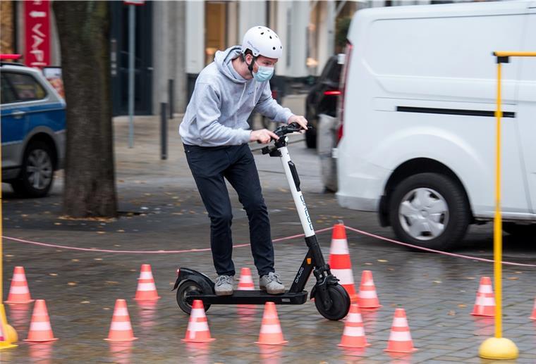 Ein Junge fährt mit dem E-Scooter. 