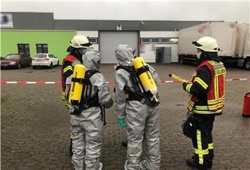 Feuerwehrleute in Schutzanzügen.