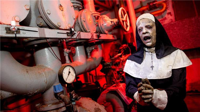 Erschrecken und Gruseln zu Halloween - Gruselhäuser Die Figur einer Nonne steht im illuminierten Heizungskeller eines ehemaligen Busdepots, in dem die temporäre Attraktion „Das Spukhaus 2023“ aufgebaut wurde.
