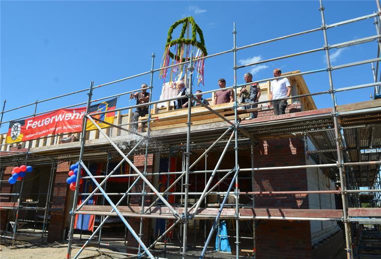 Die Flasche ging beim Richtspruch der Zimmerer für das neue Schiffdorfer Feuerwehrhaus zu Bruch, die Scherben sollen dem Bau traditionell Glück bringen.