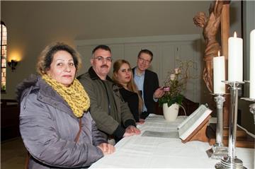 Die Flüchtlinge Mahvash Lashmarzamakhi Rahin (von links), Hassan Ahmed und Parinaz Ghahnavyeie Ahmadzadeh stehen mit Pastor Götz Weber am Altar der Kreuzkirche. Webers Gemeinde im Stadtteil Mitte verzeichnet die meisten Flüchtlingstaufen in Bremerhaven.