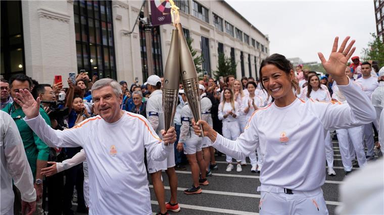 Die französische Handballerin Cleopatre Darleux übergab die olympische Fackel an IOC-Chef Thomas Bach.