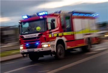 Ein Fahrzeug der Feuerwehr fährt mit Sonderrechten (Blaulicht) über eine Straße.