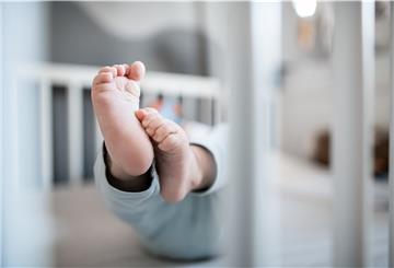 Die Füße eines Babys in einem Kinderbett.