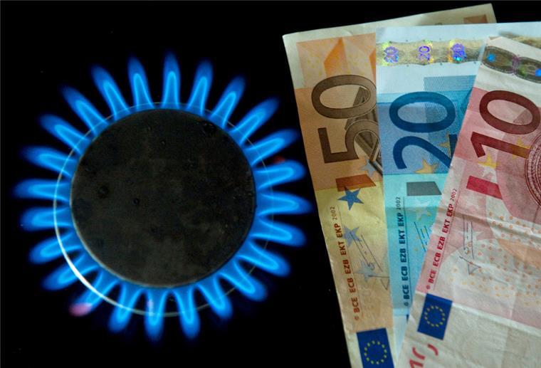  Euro-Scheine liegen neben einer Gasflamme auf einem Küchenherd 