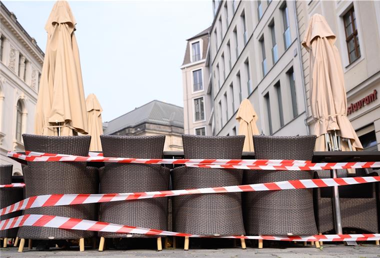 Gastgewerbe sieht Ostergeschäft verloren Ein Absperrband umgibt Tische und Stühle vor einem Restaurant