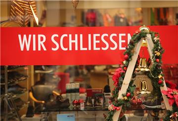 Auf einem Ladenschild steht  "Wir schließen". 
