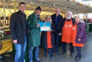 Scheckübergabe am Mittwoch auf dem Geestemünder Wochenmarkt in Bremerhaven (v.l.n.r.): Lars Jansen (Bereichsleiter Großmarkt Bremen), Olaf Dietzel (Marktsprecher Wochenmarkt Geestemünde), Gaby Treschok (Projektmanagerin Tafel Bremerhaven), Torsten von Haaren (Stadtverordnetenvorsteher Bremerhaven), Manfred Jabs und Natalia Afanasieva (Tafel Bremerhaven).